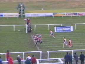 Geoff Keen finishing inches ahead of D. Prowse (wearing black tights) in the 90m Open final. W. McGowan is close behind.